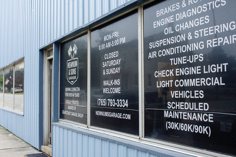 Newnum & Sons storefront window listing air conditioning repair and engine diagnostics