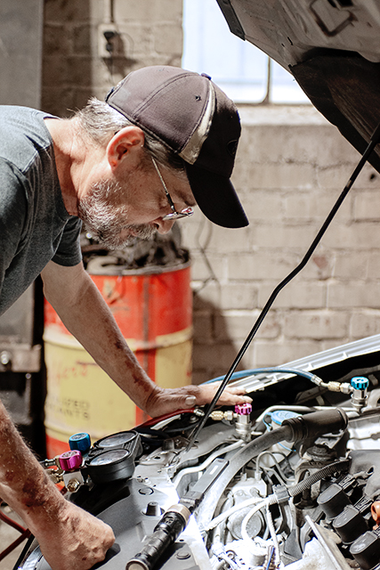 Technician checking the engine bay during a vehicle diagnostic in Covington, IN