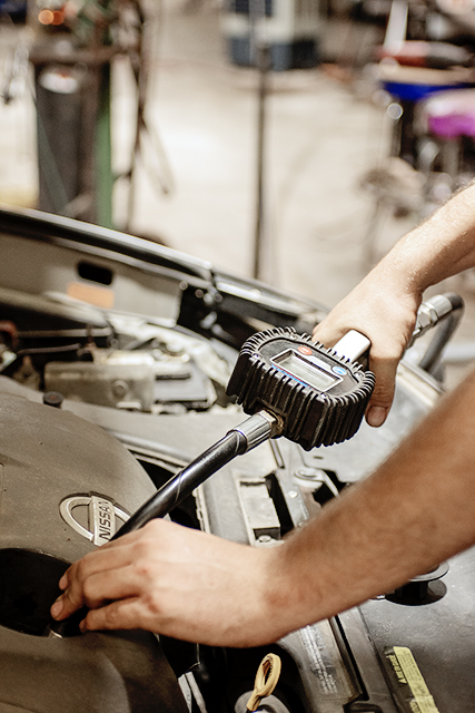 Close-up of a technician testing components under the hood
