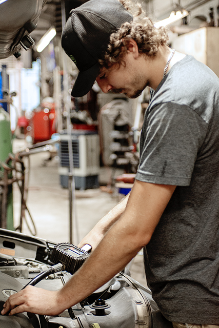 Technician working on an engine under the hood at Newnum & Sons Garage
