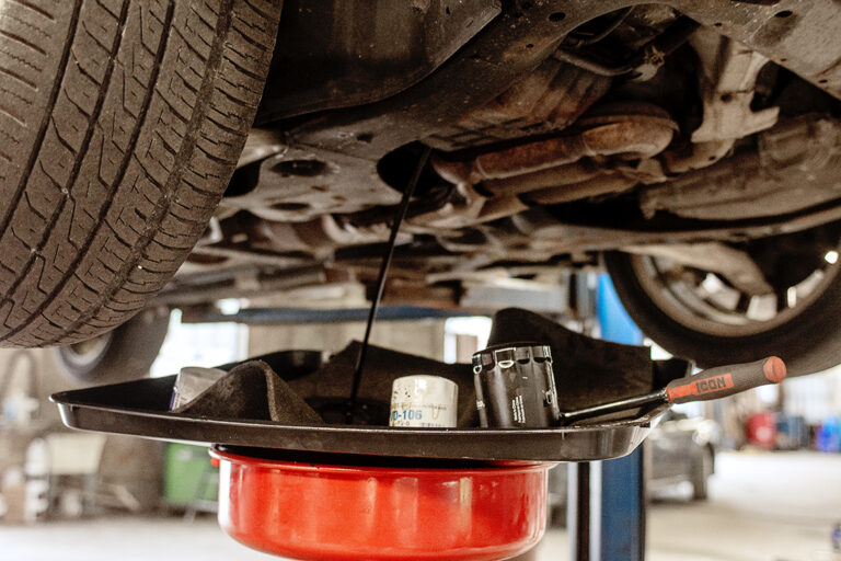 Used oil draining into a collection pan under a vehicle