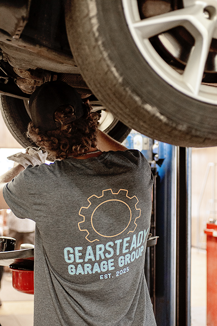 Technician working underneath a raised vehicle at Newnum & Sons Garage