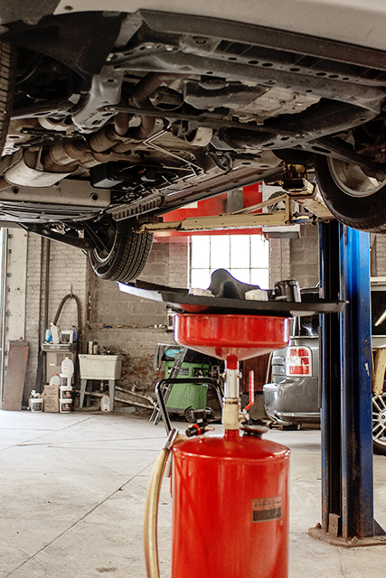 Vehicle on a lift with a fluid drain positioned for transmission service