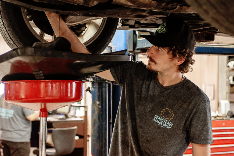 Technician inspecting the underside of a vehicle at Newnum & Sons Garage